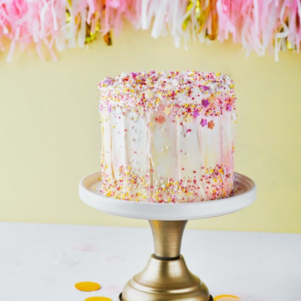 colorful-birthday-cake-with-sprinkles-on-a-yellow-background-.jpg